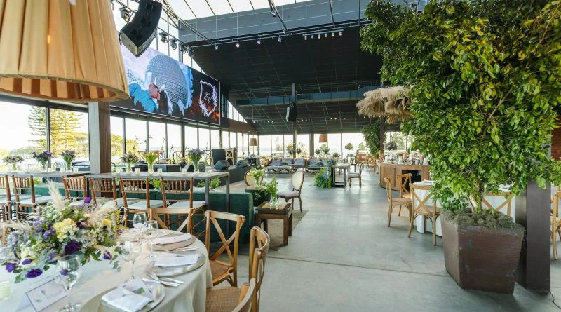 A beautifully decorated indoor reception venue with floral arrangements and elegant table settings.