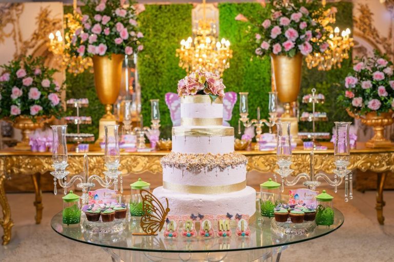Luxurious quinceañera setup with a grand cake, florals, and upscale decor in a vibrant setting.