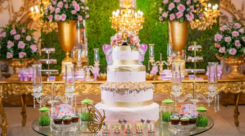 Luxurious quinceañera setup with a grand cake, florals, and upscale decor in a vibrant setting.